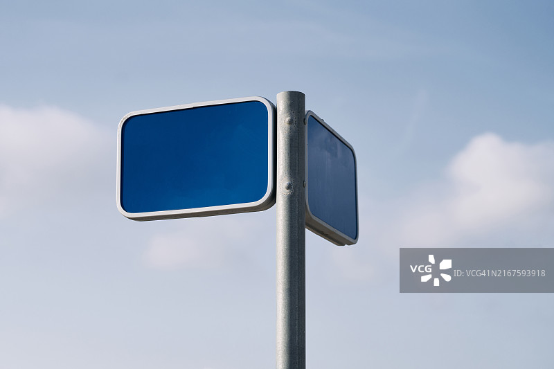 人行道上金属杆上的蓝色空标志牌正面景观图片素材