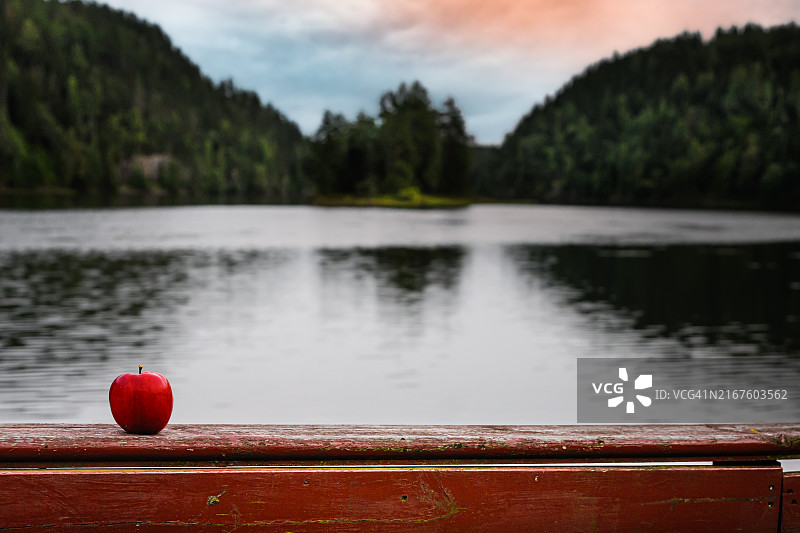 湖边红色栏杆上的苹果图片素材