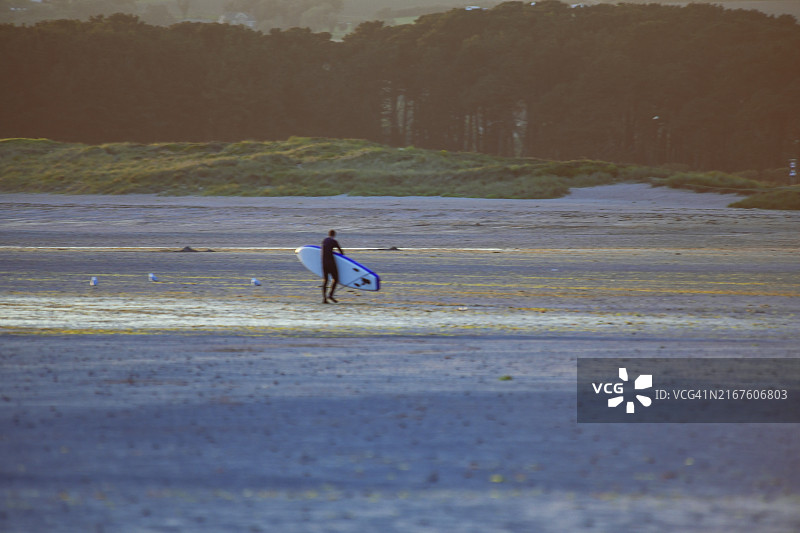 沐浴在日落光芒中的冲浪者图片素材