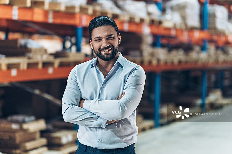 双手交叉站立的自信商人肖像图片素材