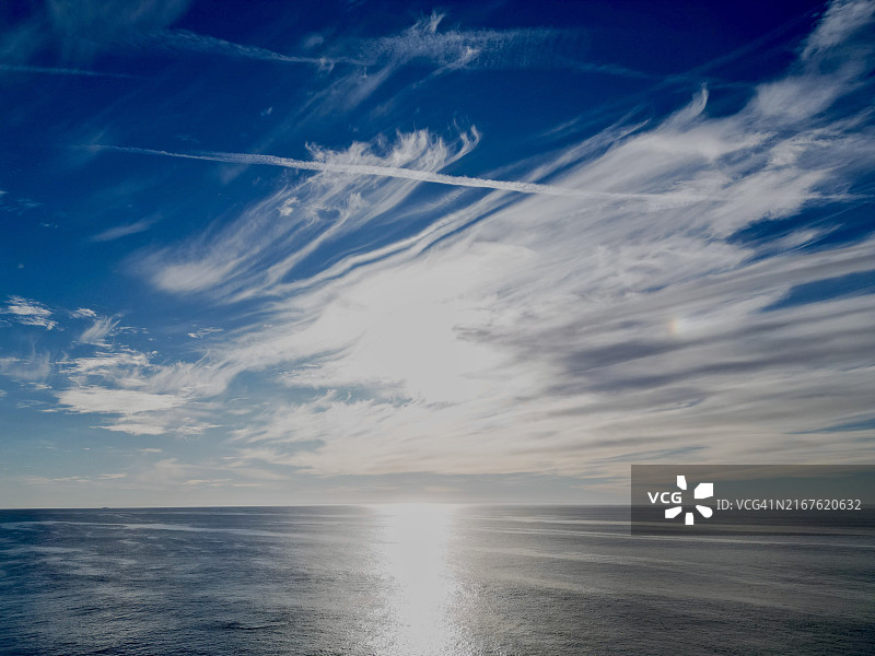 平静的海洋与缕缕云图片素材