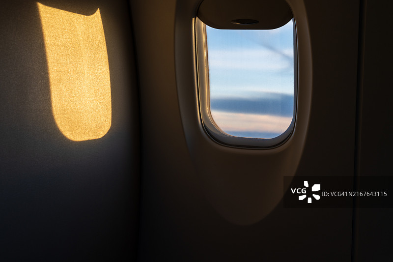 飞机机舱内金色阳光的舷窗景观图片素材