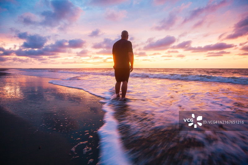 48岁男子在海滩欣赏日出图片素材