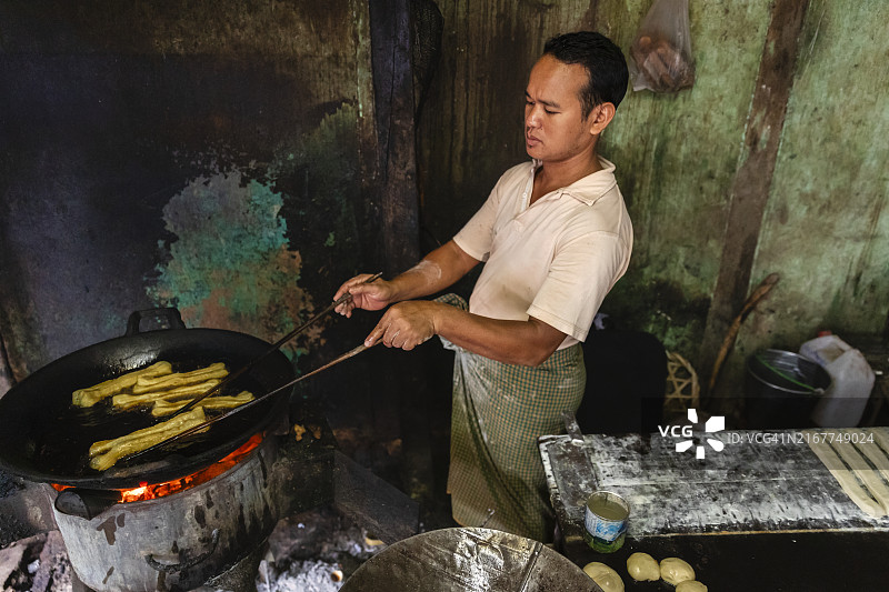 在缅甸准备和销售中式油条的男子图片素材