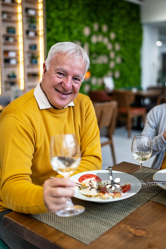 年长的男人在餐厅里举杯庆祝图片素材