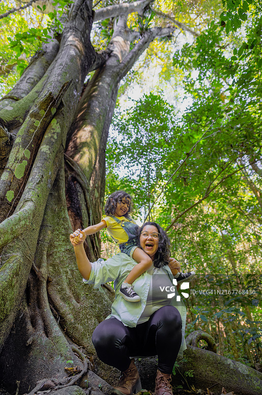 百年老树下，亚马逊雨林绿色怀抱中幸福微笑的母女图片素材