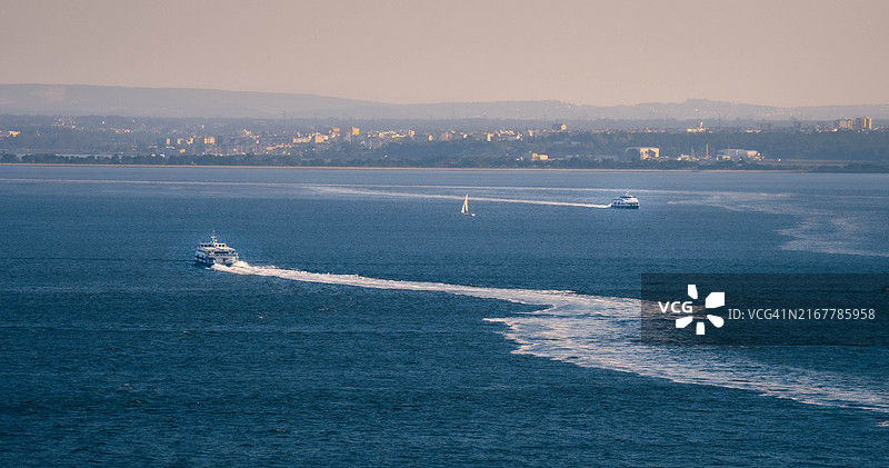 城市附近蓝色大海中的船只图片素材