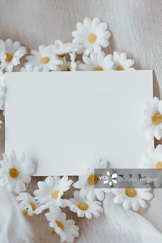 桌子上鲜花和白色空白纸张的俯视图图片素材