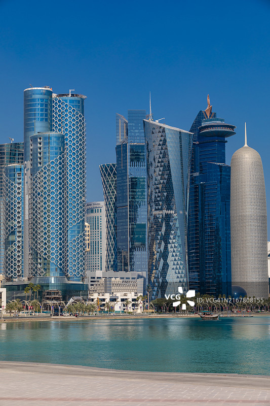 卡塔尔多哈西湾天际线下的传统单桅帆船图片素材