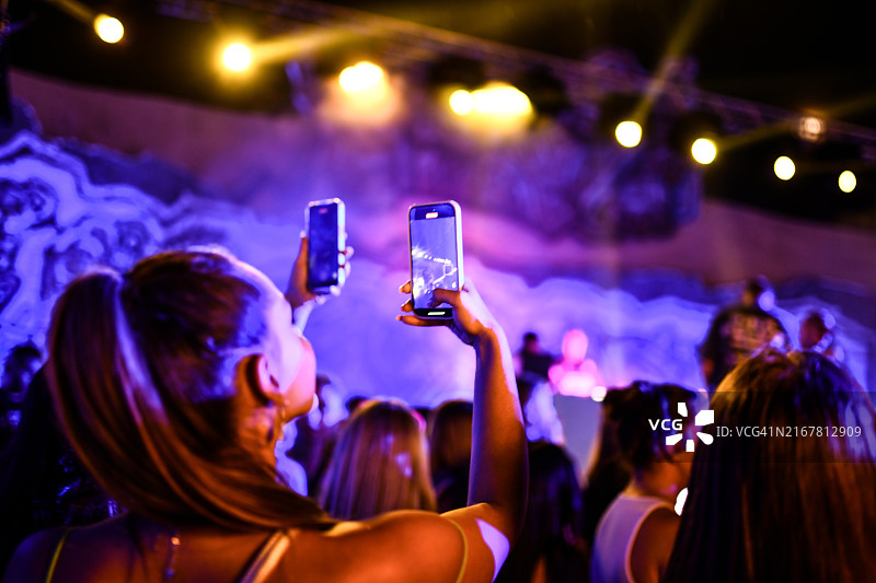 派对期间人们录制DJ现场表演图片素材