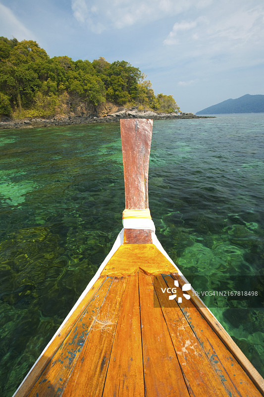 泰国达鲁岛国家公园长尾船船头，俯瞰清澈海水和珊瑚礁图片素材