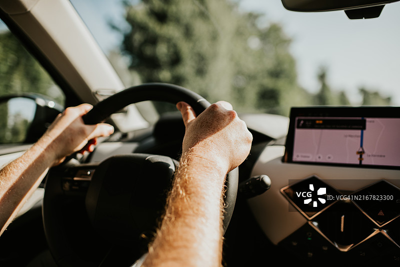 男人驾驶现代汽车，使用仪表盘屏幕上的卫星导航图片素材