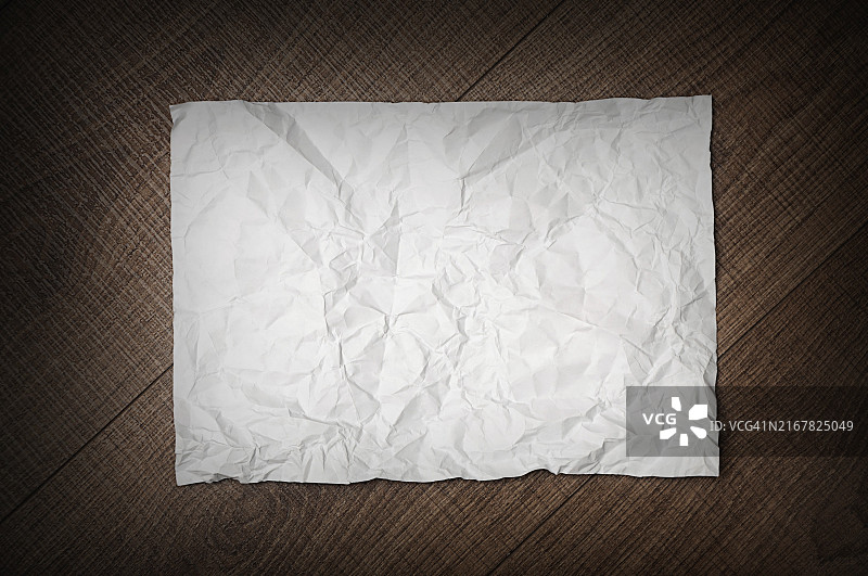 深棕色木质背景上的皱纸图片素材