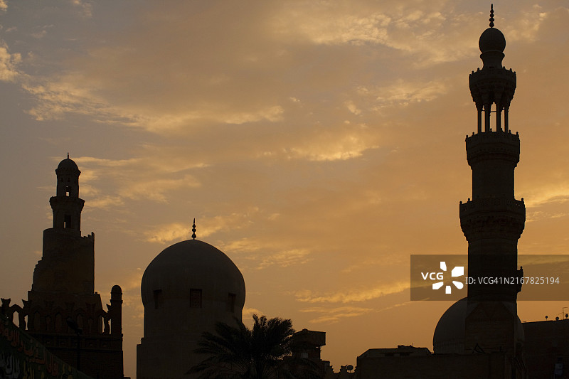 埃及开罗，伊本·图伦清真寺的圆顶和尖塔在日落时分的剪影图片素材