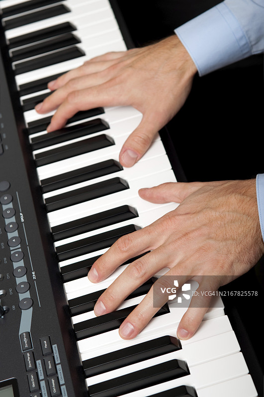 男人在工作室弹钢琴的特写镜头图片素材
