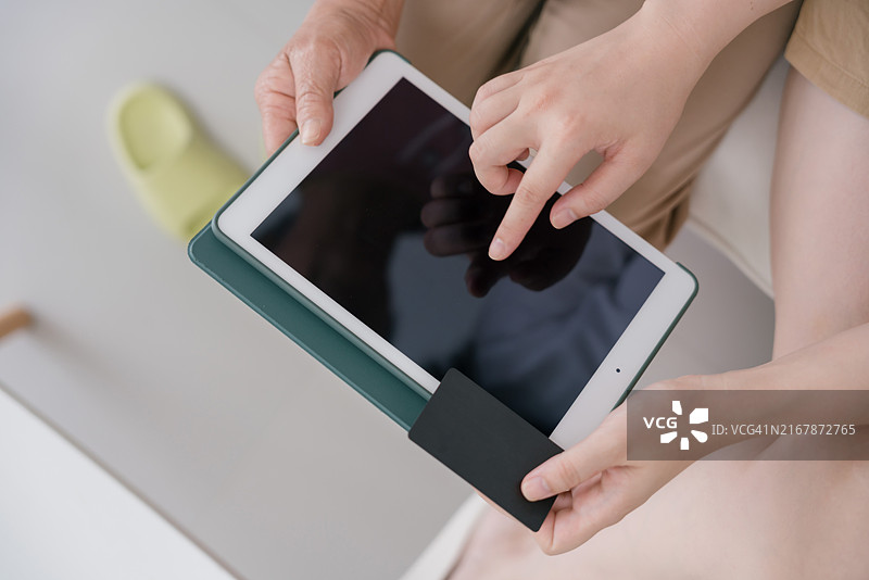 多代同堂的家庭在家中使用平板电脑进行在线购物图片素材
