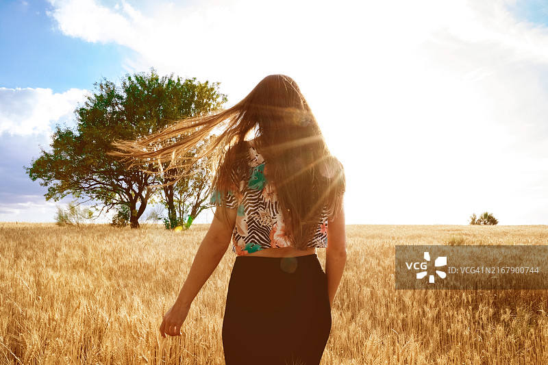 在乡村日落时分，头发蓬乱的女子图片素材