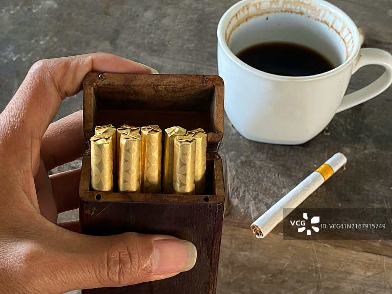 手持装满雪茄的木制烟盒图片素材