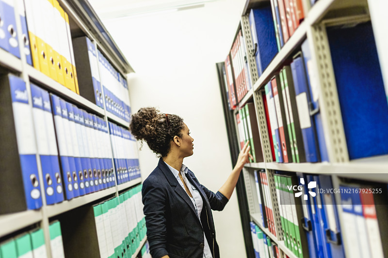 在档案室查找文件夹的女职员图片素材