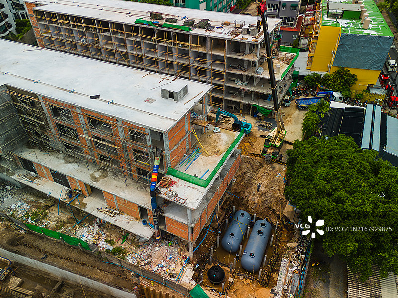 大型建筑工地鸟瞰：工人与起重机移动化粪池或水箱图片素材