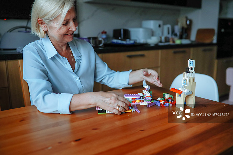 老年奶奶和保姆在厨房玩积木图片素材
