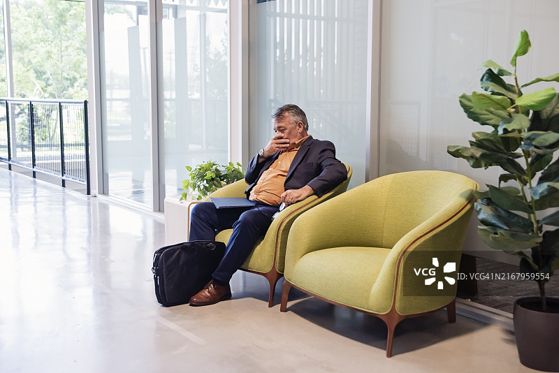 在开放工作区等待面试的压力大的老年男子图片素材