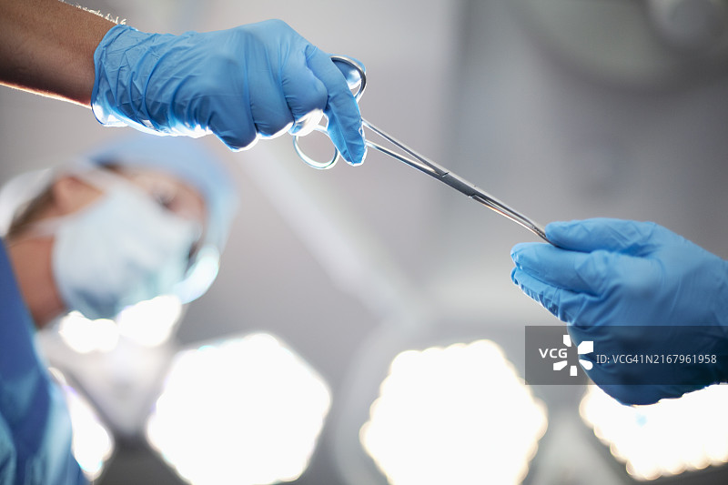 医生、外科医生和护士在手术室传递医疗设备（低角度视角）图片素材