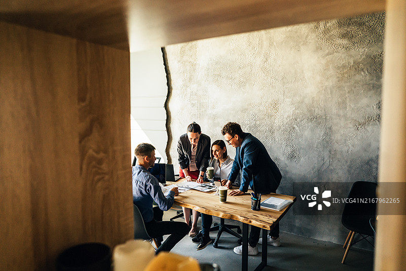 四位同事坐在办公室的桌子旁图片素材