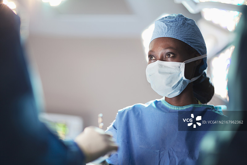 在医院手术室与医疗同事在一起的非洲裔女医生肖像图片素材