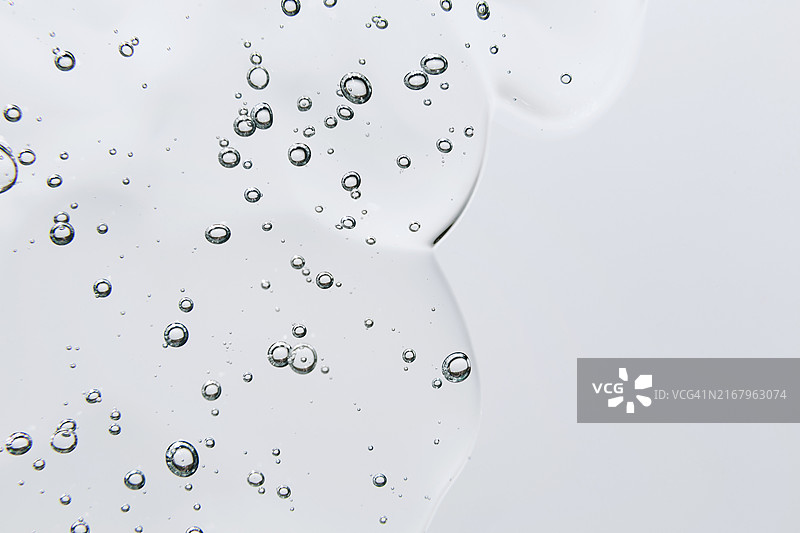 白色背景上的透明气泡化妆品凝胶，透明质酸液体凝胶图片素材