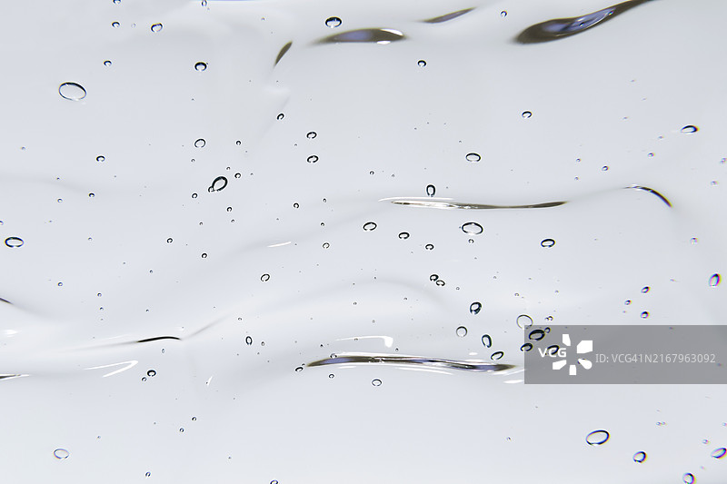 白色背景上的透明凝胶或精华液化妆品气泡质地，液态玻尿酸凝胶图片素材