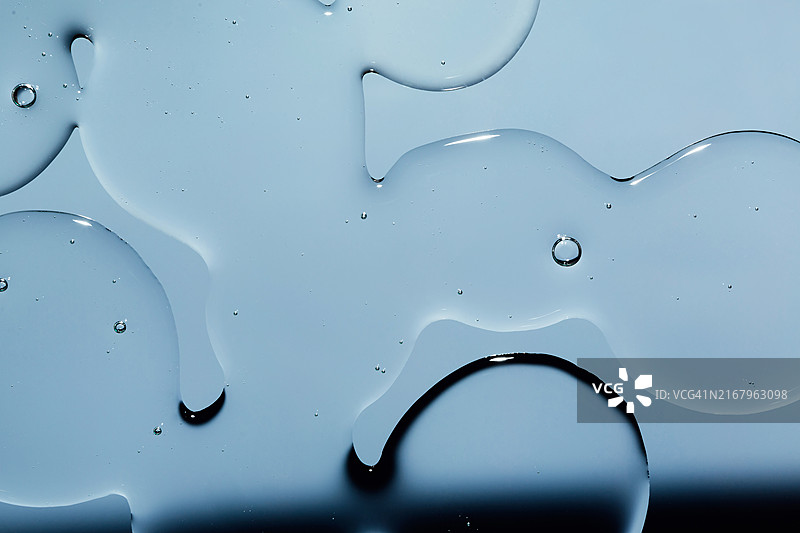 浅蓝色背景上的透明气泡凝胶霜：液态透明质酸凝胶，俯视图图片素材