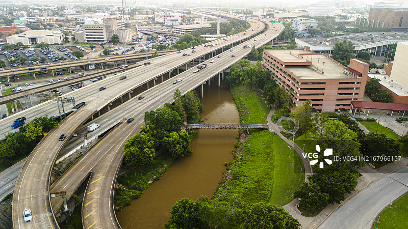 德克萨斯州蜿蜒高速公路上的繁忙交通：布法罗河口与休斯顿市中心的高架海湾高速公路相交图片素材