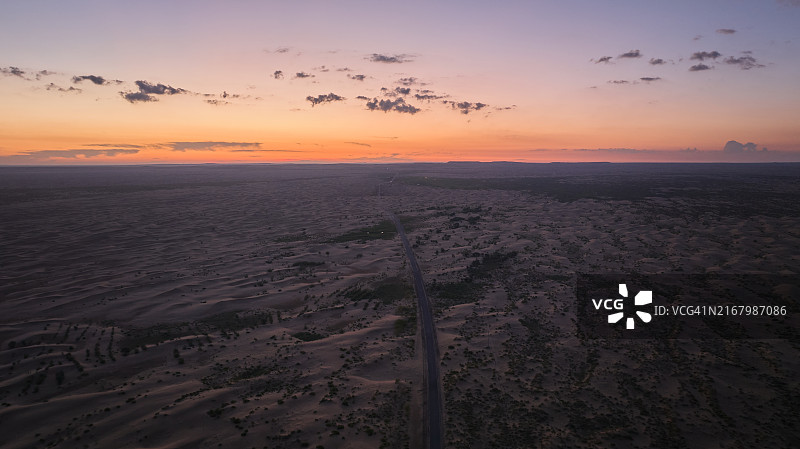 沙漠公路日落：无尽沙丘航拍全景图片素材