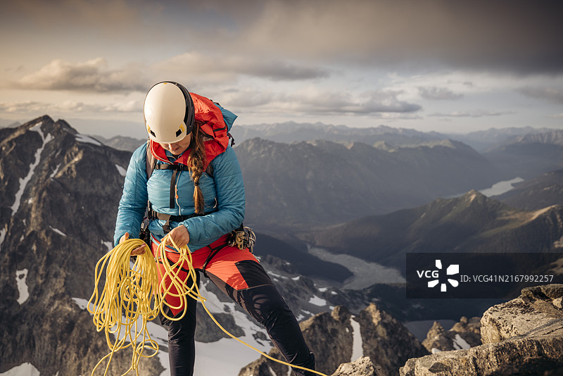 在加拿大不列颠哥伦比亚省海岸山脉上准备绳降的登山者图片素材