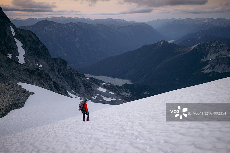 登山者在日落时分下降雪山图片素材