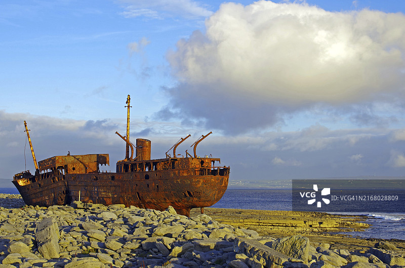 岩石海岸上的生锈沉船，天空广阔，位于爱尔兰阿伦群岛图片素材