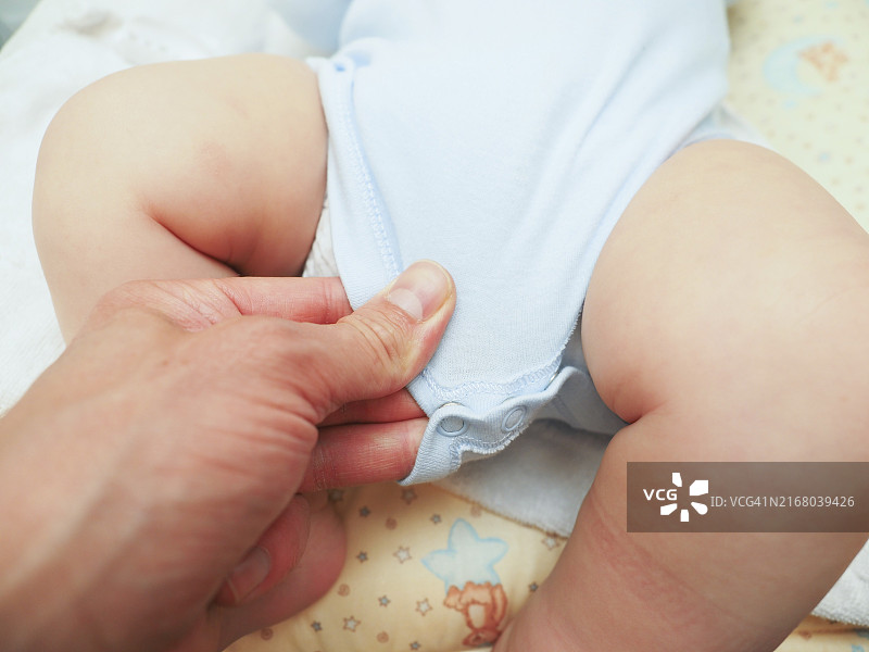 给男婴洗澡和更换尿布后穿衣服图片素材