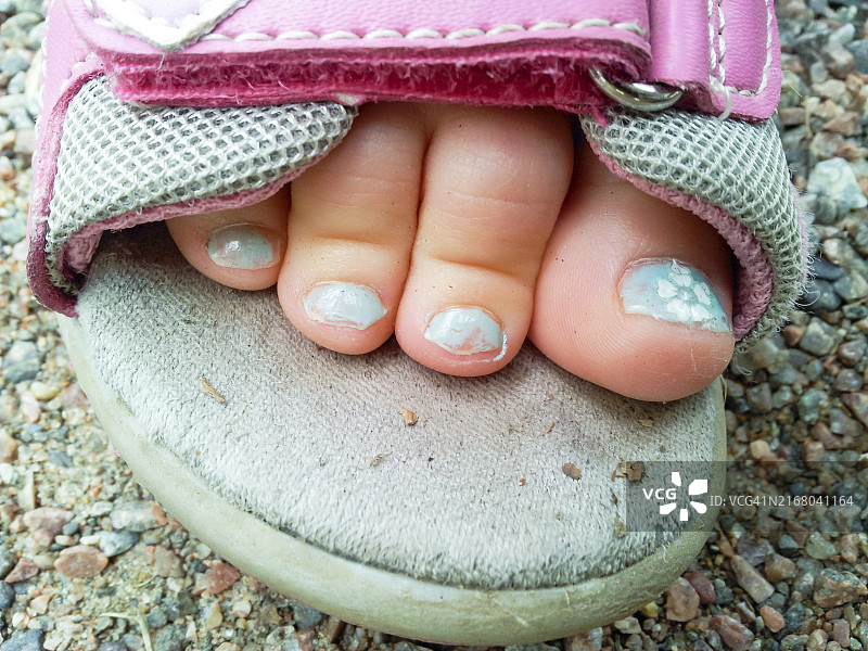 凉鞋里孩子脚上漂亮的蓝色修脚图片素材
