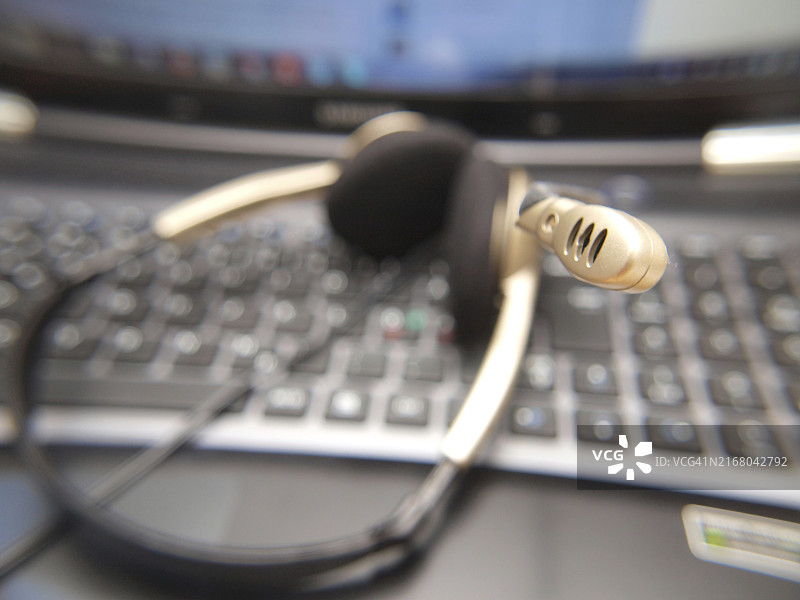 电脑键盘上的耳机麦克风特写图片素材
