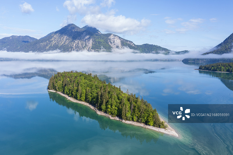 德国巴伐利亚州：瓦尔兴湖中萨绍小岛的鸟瞰图，背景是笼罩在雾中的赫尔佐格斯丹山图片素材