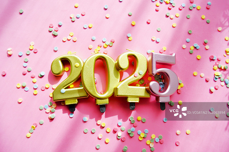粉色背景上的金色2025年及彩色纸屑图片素材