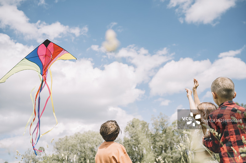 女孩和兄弟在晴天放风筝图片素材