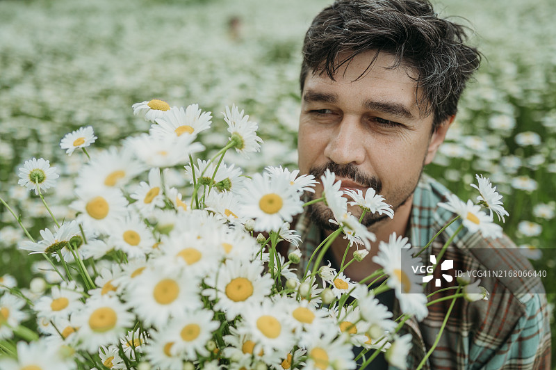 手持雏菊花束的成熟男人图片素材