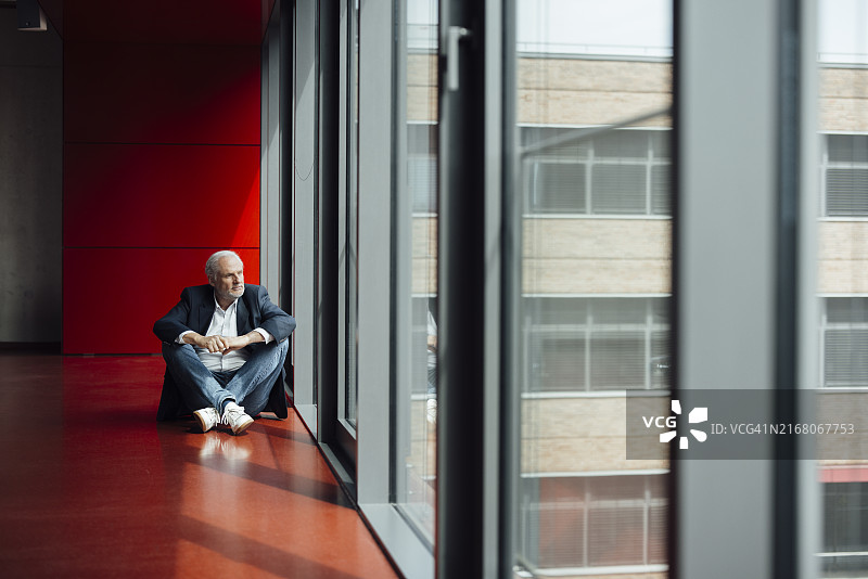 在办公室里翘着二郎腿看窗外的商人图片素材
