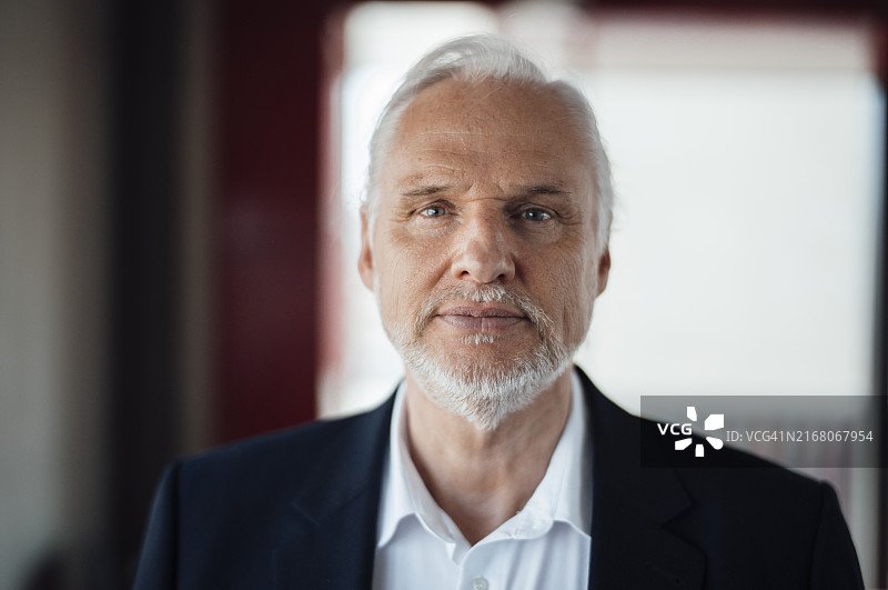 自信的年长商人，面带白色胡茬在办公室图片素材