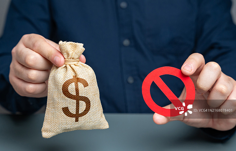 商人拿着美元钱袋和红色禁止标志，拒绝交易，资本外流限制，制裁，外币兑换储备多样化，预算削减图片素材