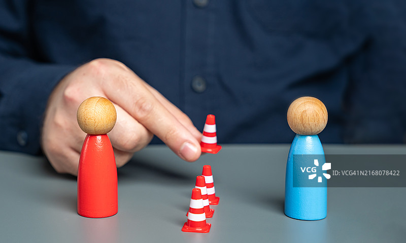 男人在冲突人群之间设置路锥障碍：冲突分界线、解决冲突与调解概念图片素材