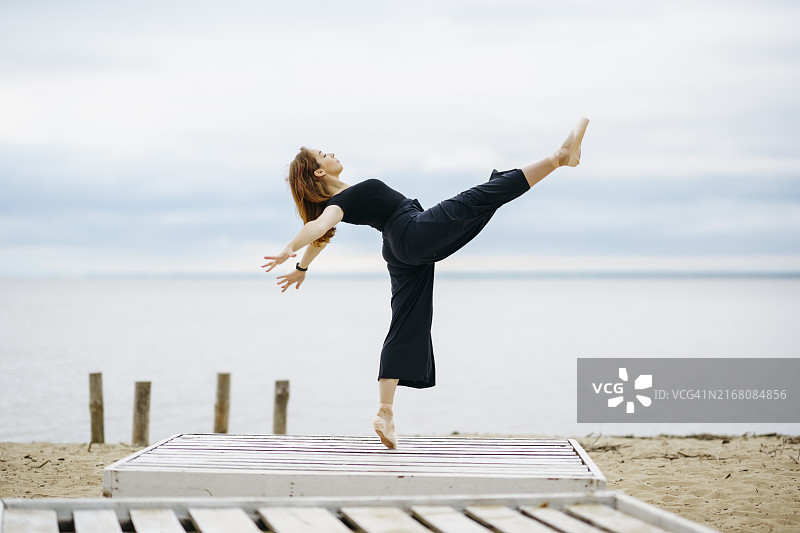 在湖边踮起脚尖跳舞的女人图片素材