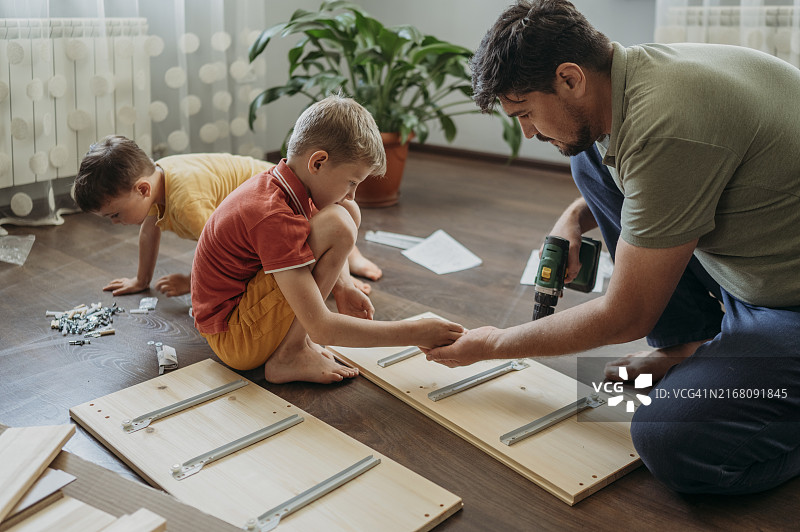 孩子们在家帮助父亲组装家具图片素材